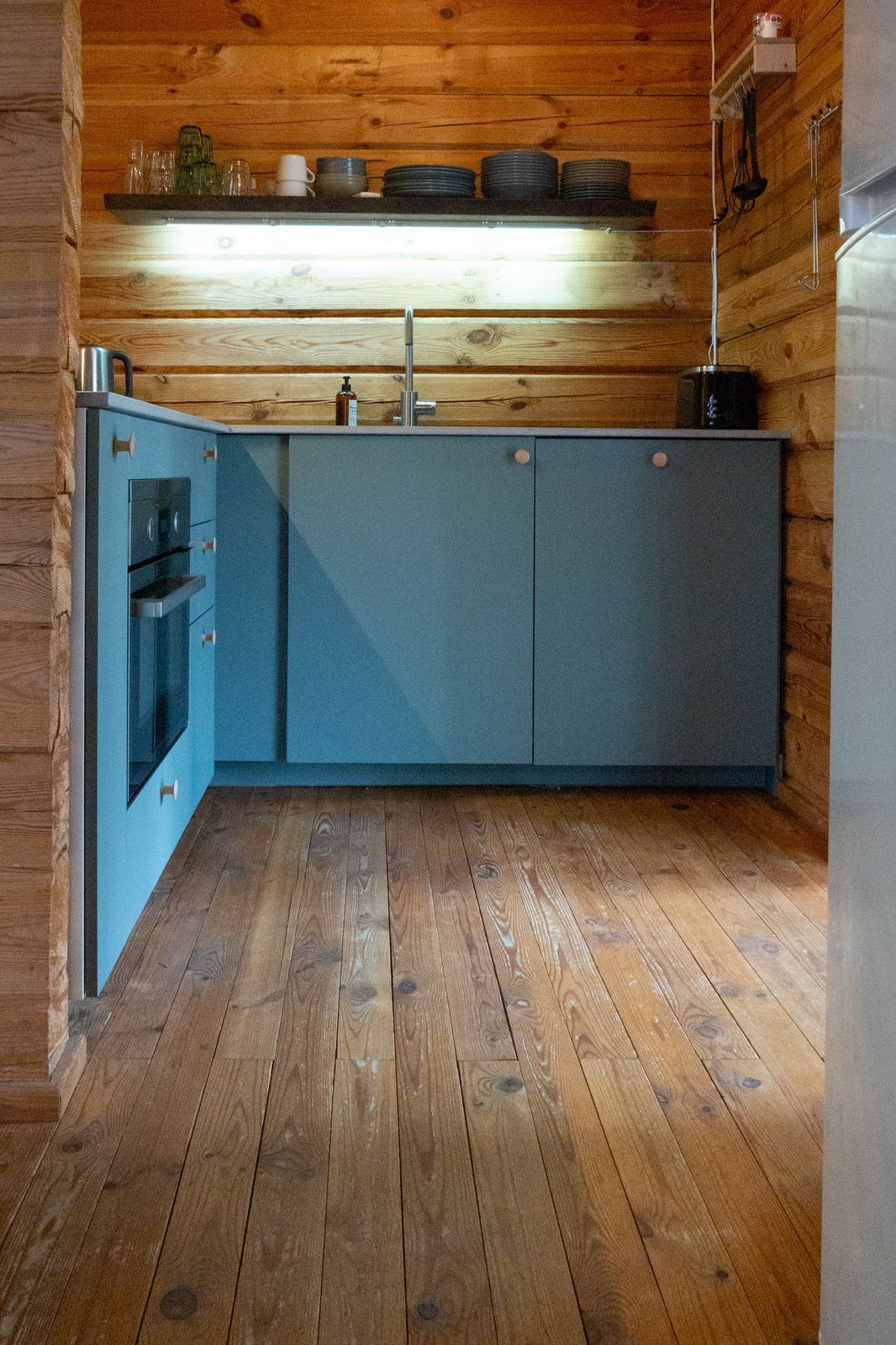 Doorkijk naar de open keuken met blauwe keukenkastjes